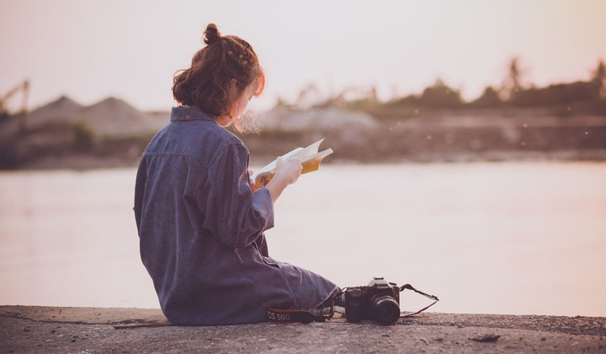 Student reading by river