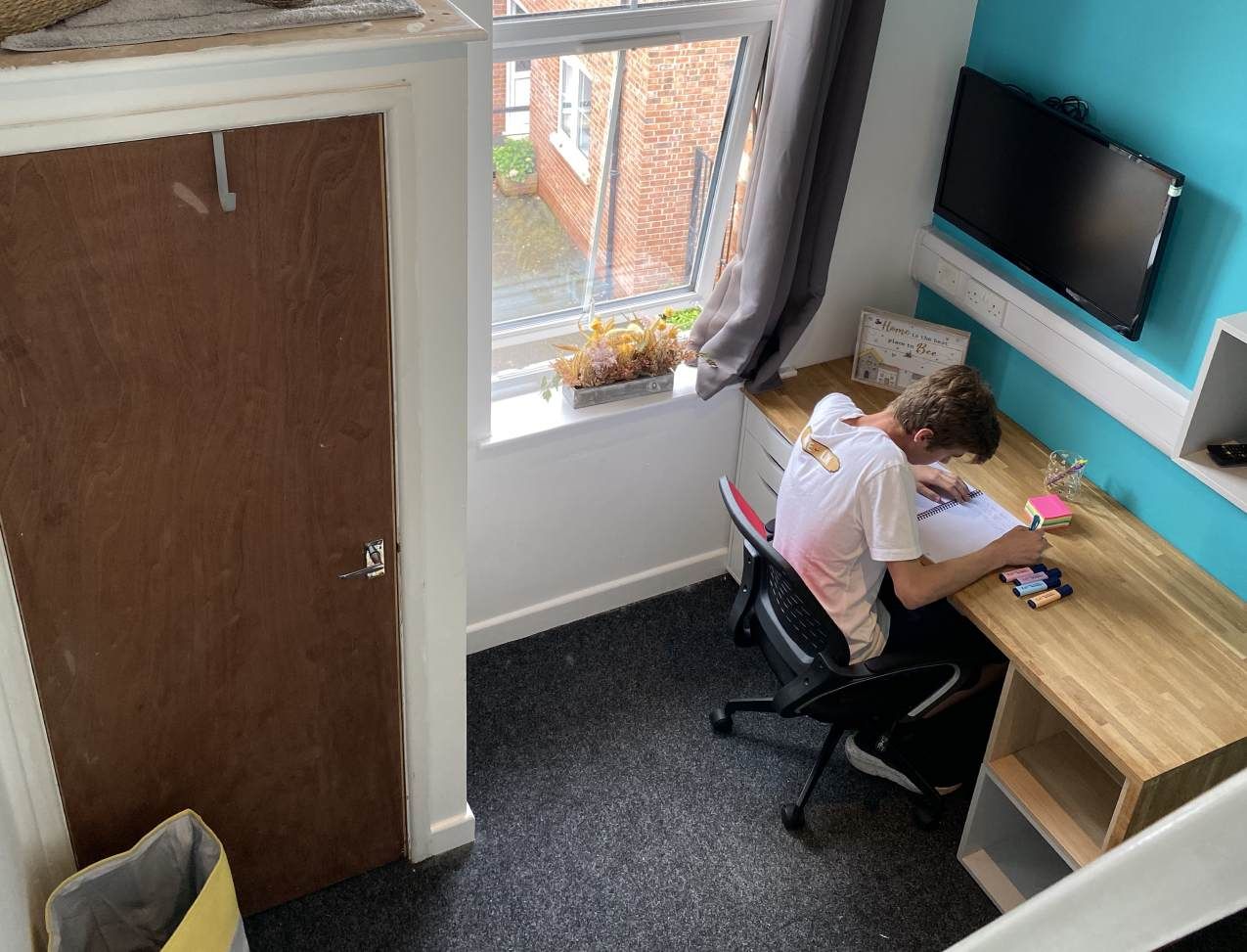 Radmoor House Student Room: Ensuite Mezzanine Room - Study area with TV, large window and cupboard